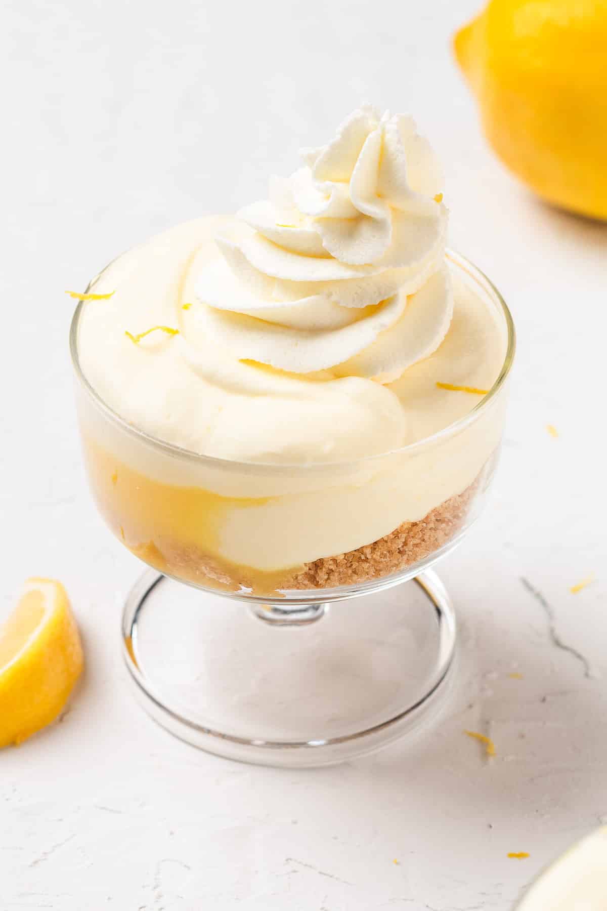 Lemon mousse cups layered with crust and topped with whipped cream.