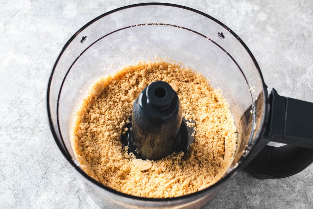 Pulverized vanilla sandwich cookies in a food processor bowl.