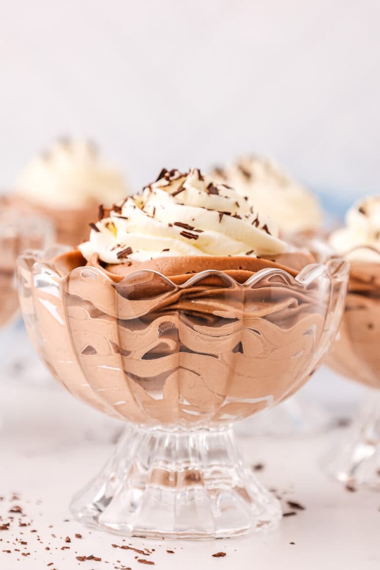 Silky Nutella mousse in a glass bowl, topped with whipped cream and chocolate shavings.