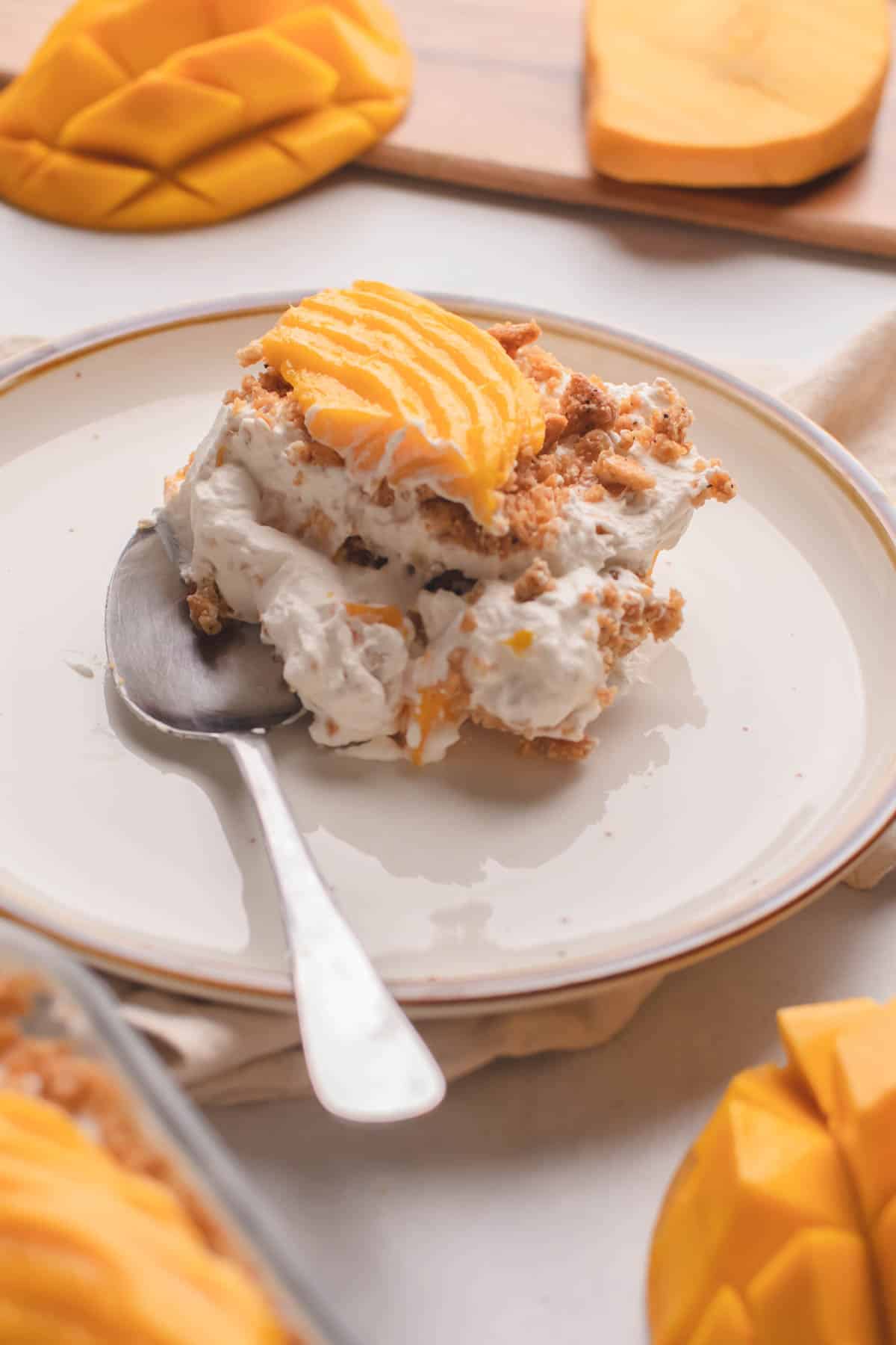 A creamy mango graham float dessert with layers of crushed graham crackers, whipped cream, and fresh mango slices.