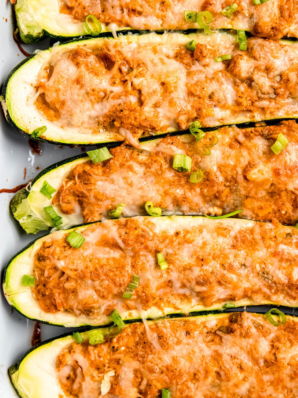 Zucchini boats filled with buffalo shredded chicken and topped with melted cheese.
