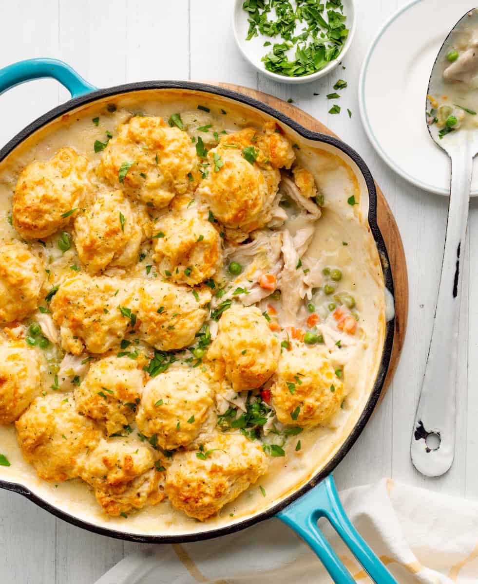 Skillet filled with creamy chicken and vegetables, topped with cheddar biscuits.