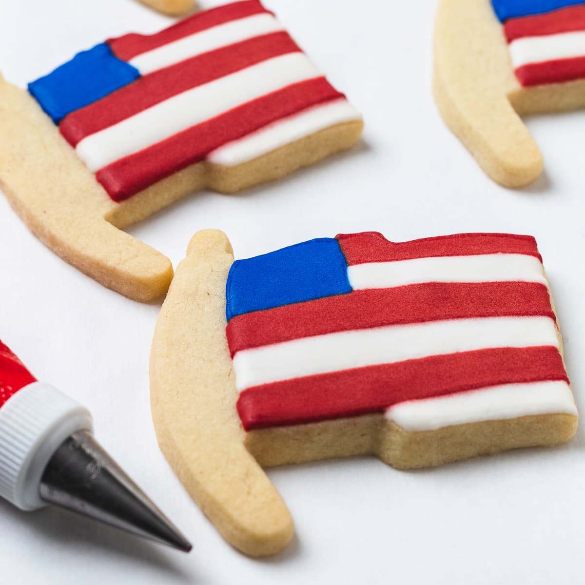 Cut out flag sugar cookies with red, white, and icing.