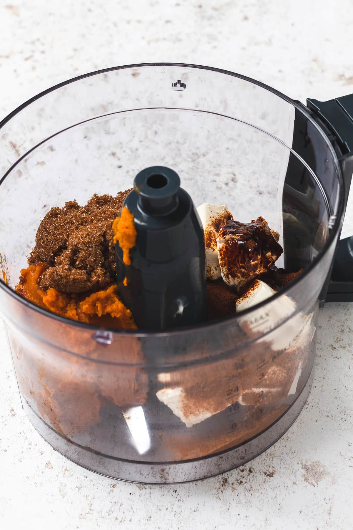 Ingredients for pumpkin spice latte dip in a food processor bowl.