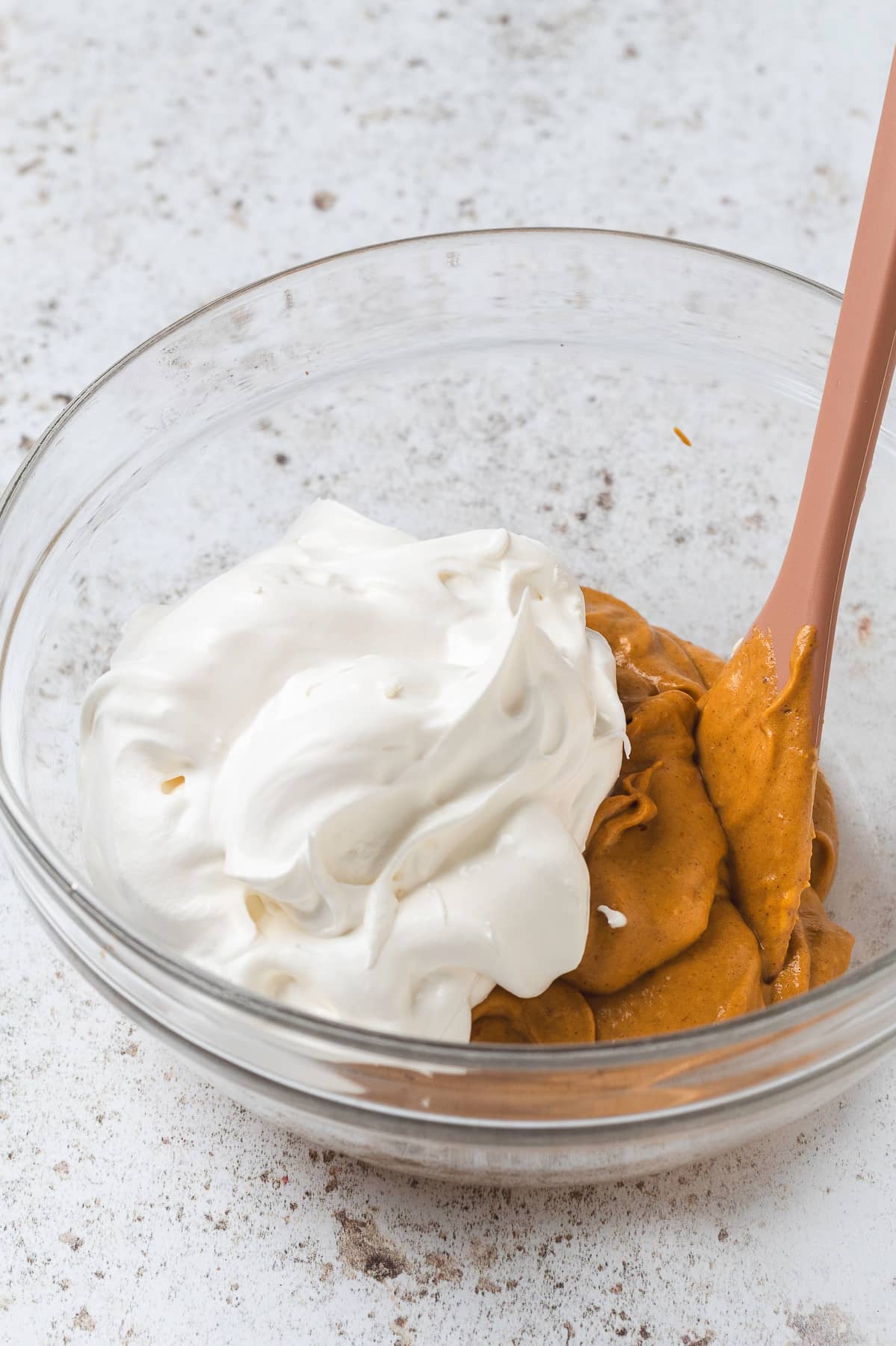 Combining pumpkin spice latte dip mixture with whipped cream.