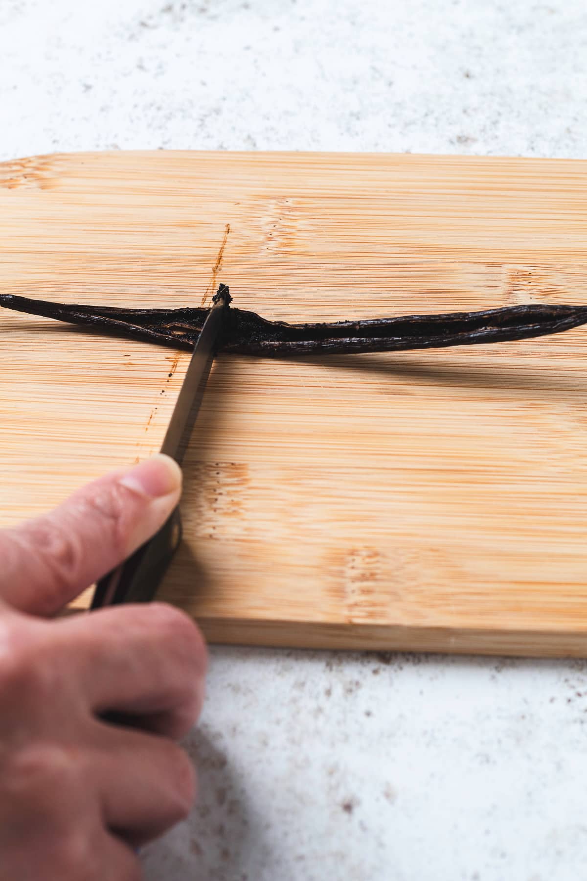 Hand cutting and scraping vanilla bean.