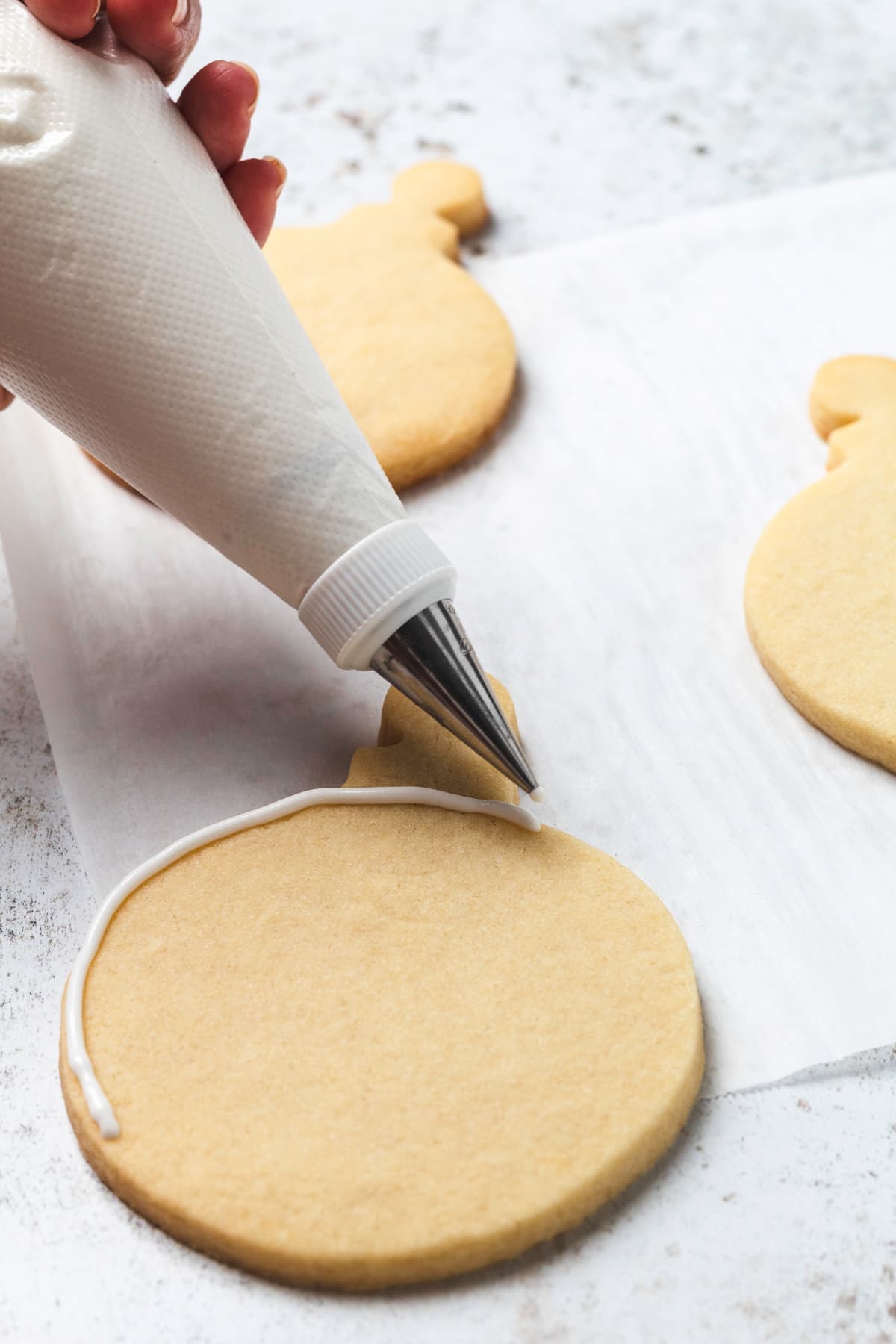 Cookie with a white icing border piped around the edge, ready for flooding.
