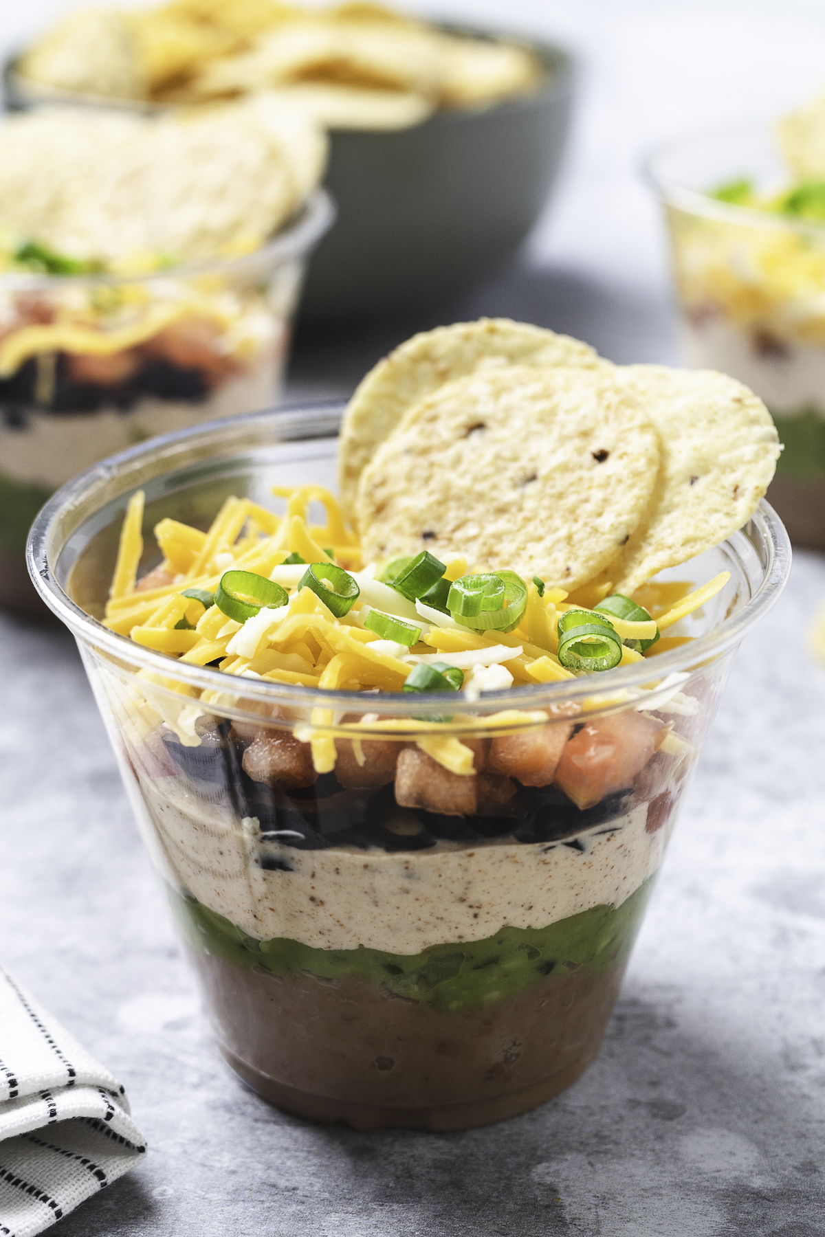 Completed taco dip cups on a gray background.