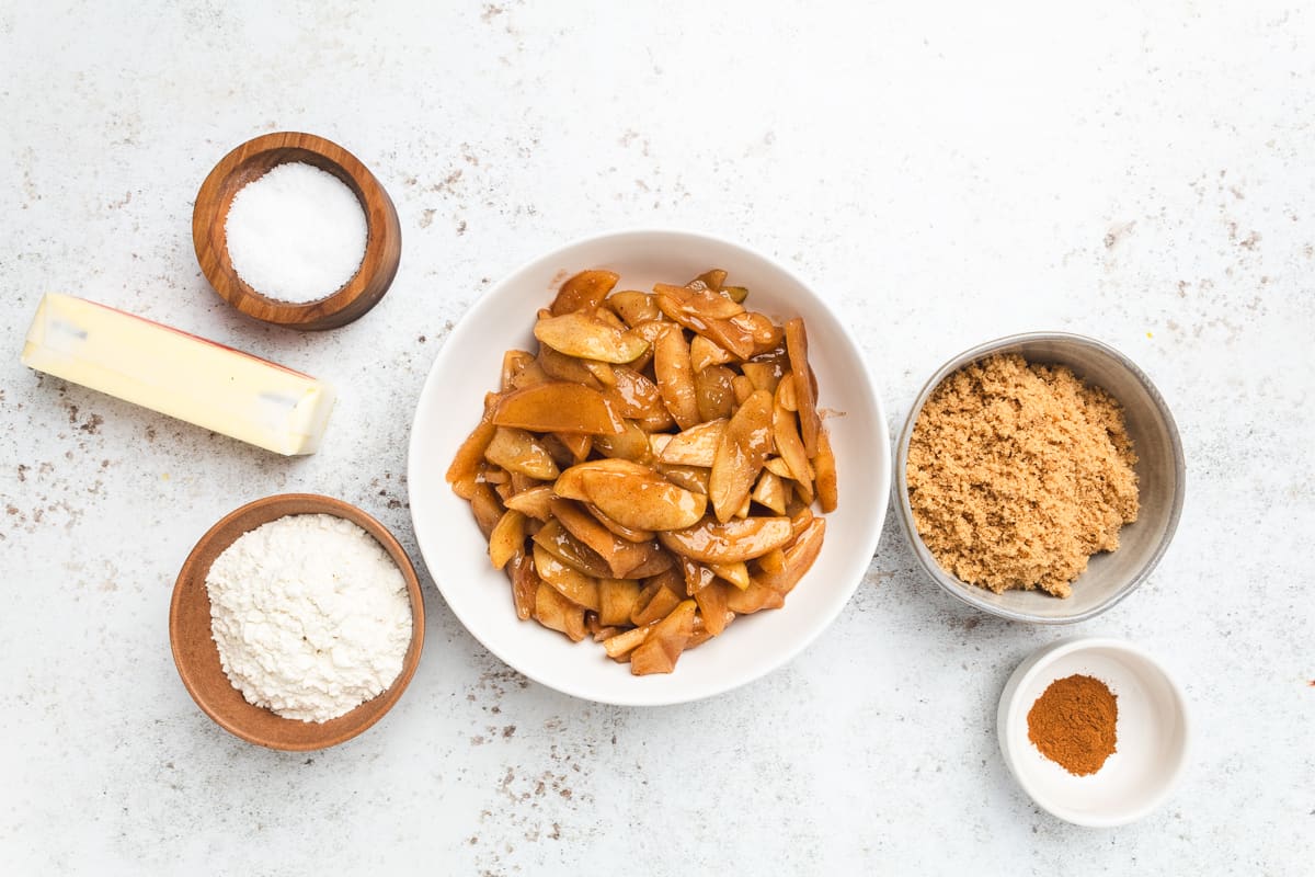 Apple crumble ingredients including apples, brown sugar, flour, butter, salt, and cinnamon.
