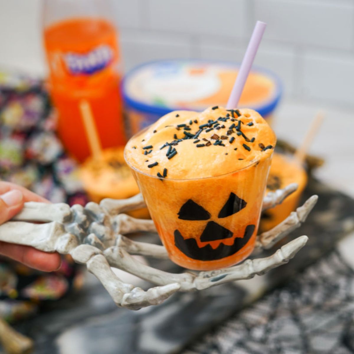 Orange Fanta float served in a Jack-o’-lantern cup with sprinkles and Halloween décor.