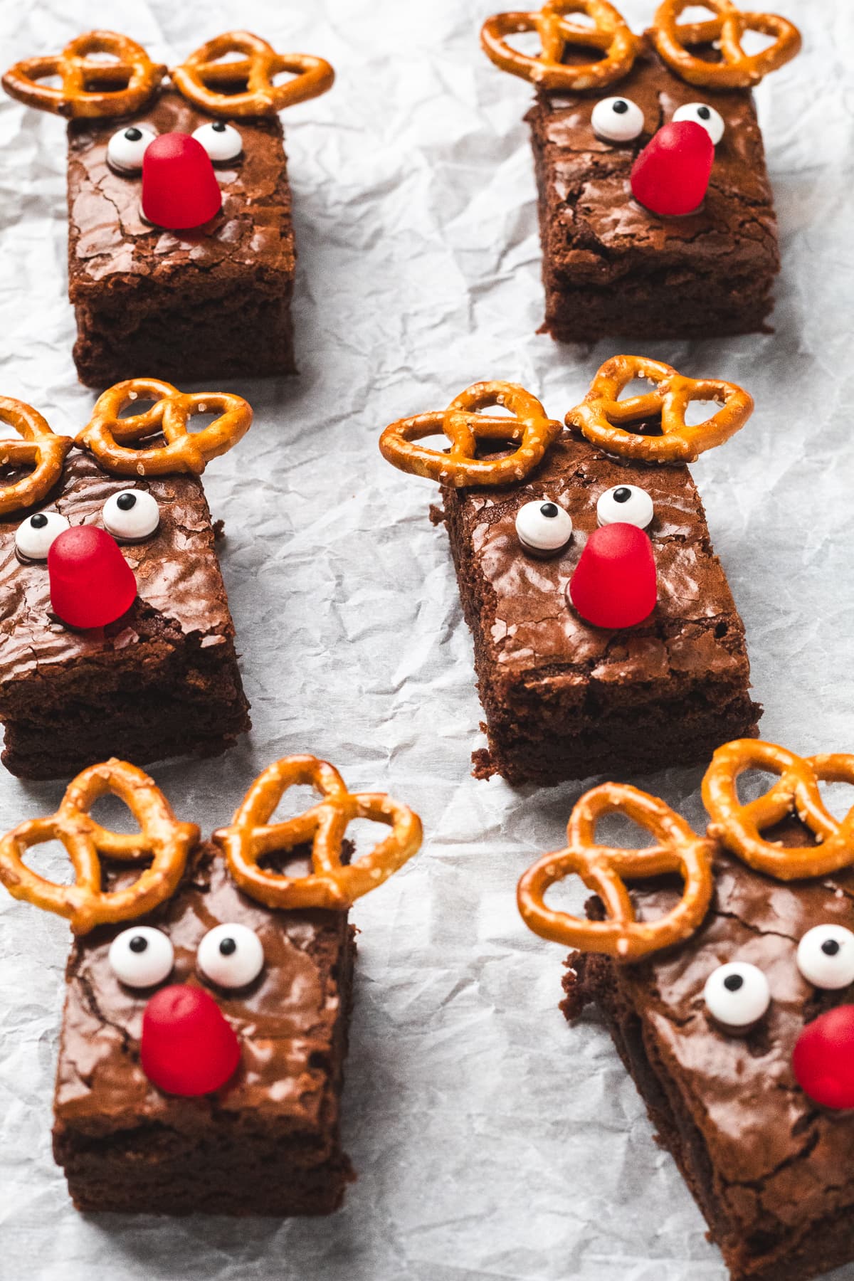 Brownies decorated as Rudolph with pretzel antlers, candy eyes, and red noses.