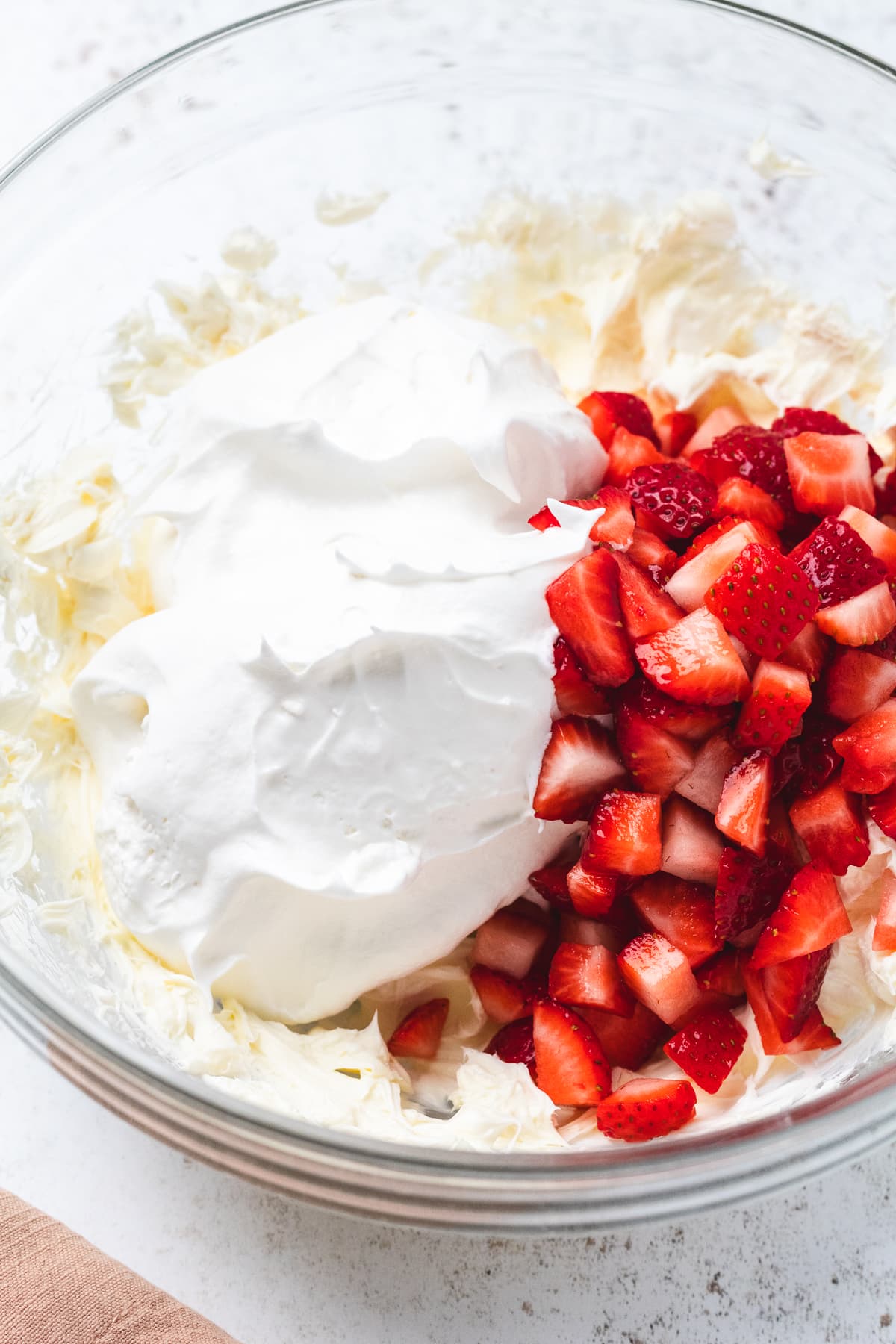 Mixing bowl with cream cheese, Cool Whip, and fresh chopped strawberries for dip.