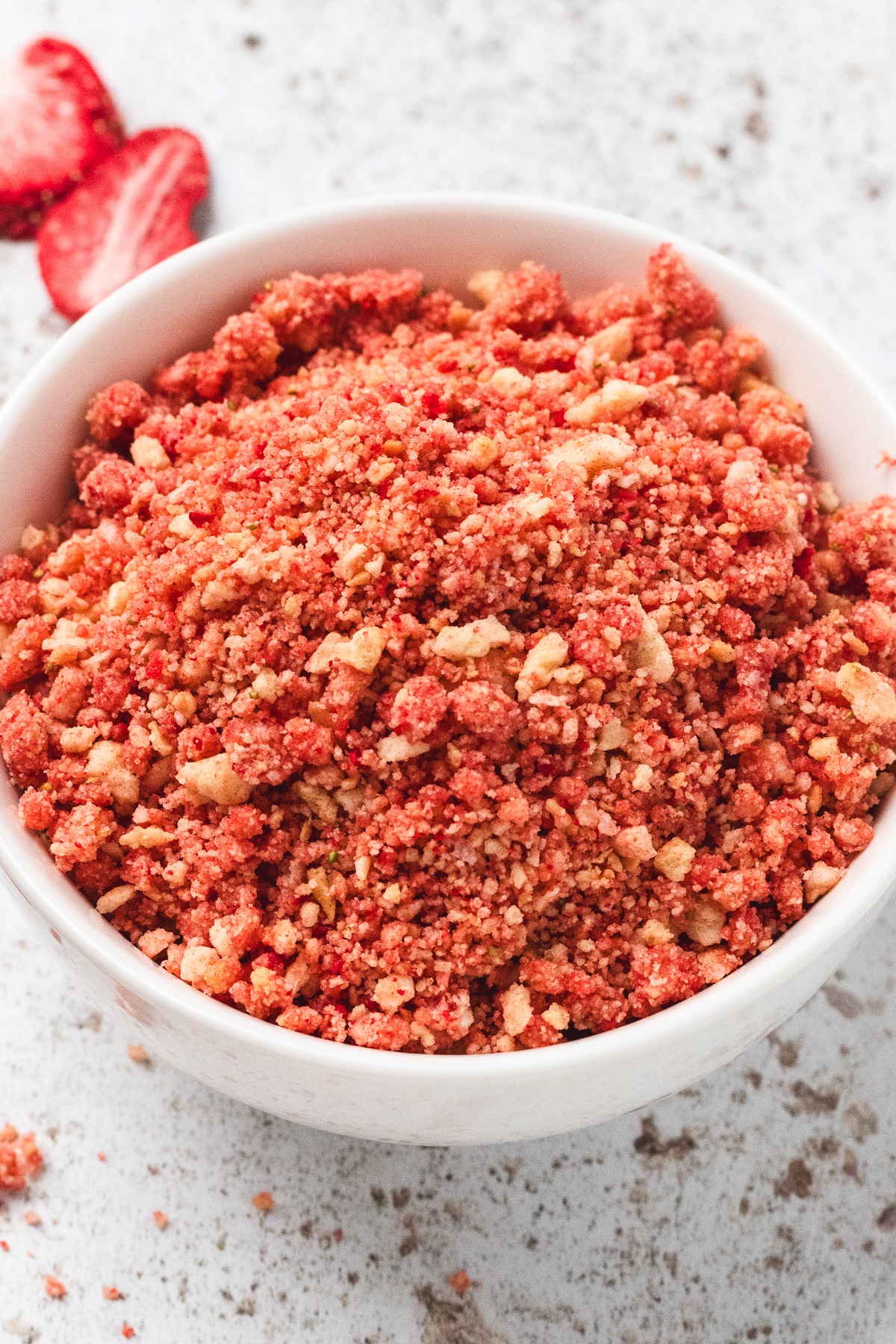 Centered image of strawberry crunch topping in a white bowl.