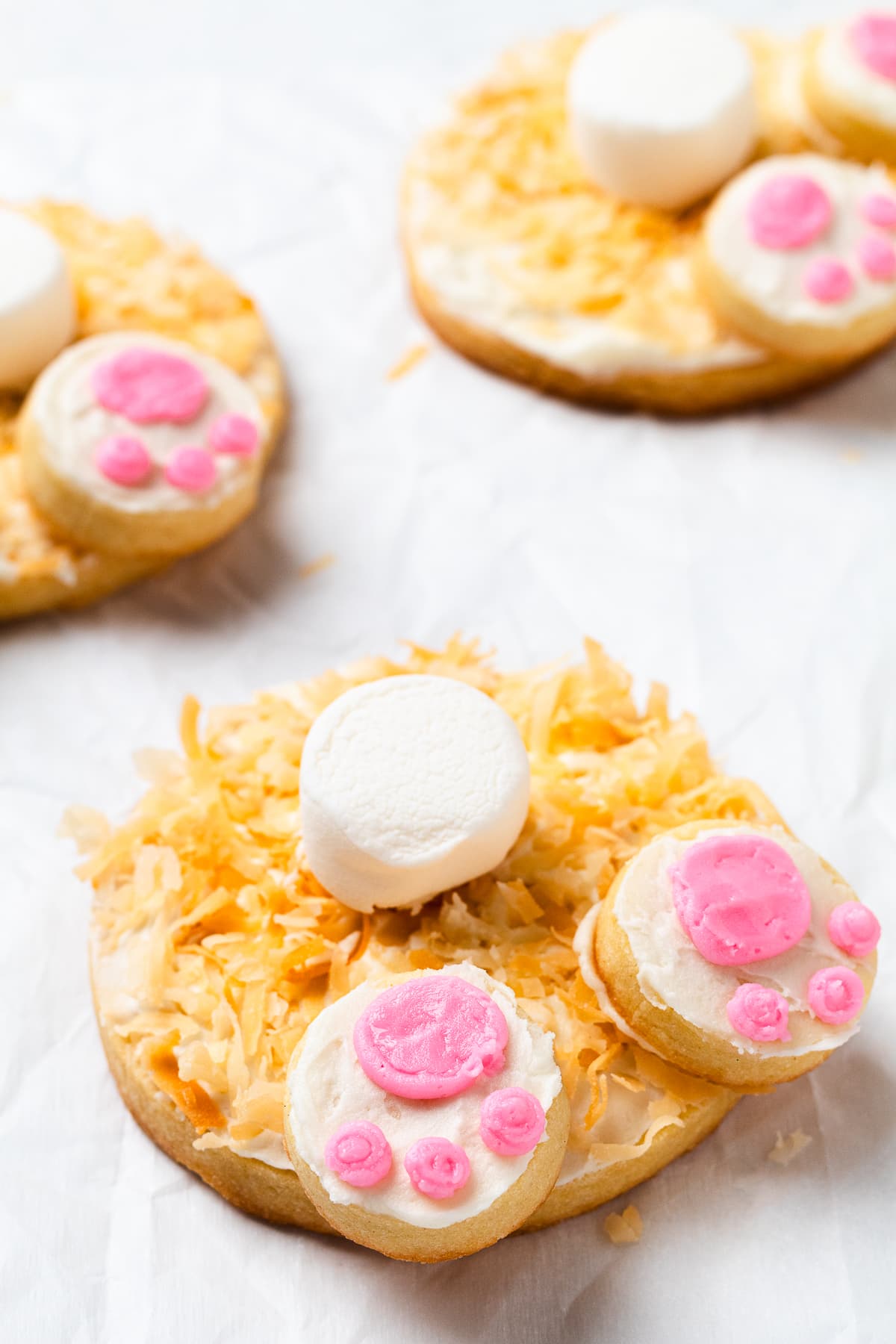Decorated bunny butt cookies with toasted coconut, marshmallow tail, and pink frosting paws.