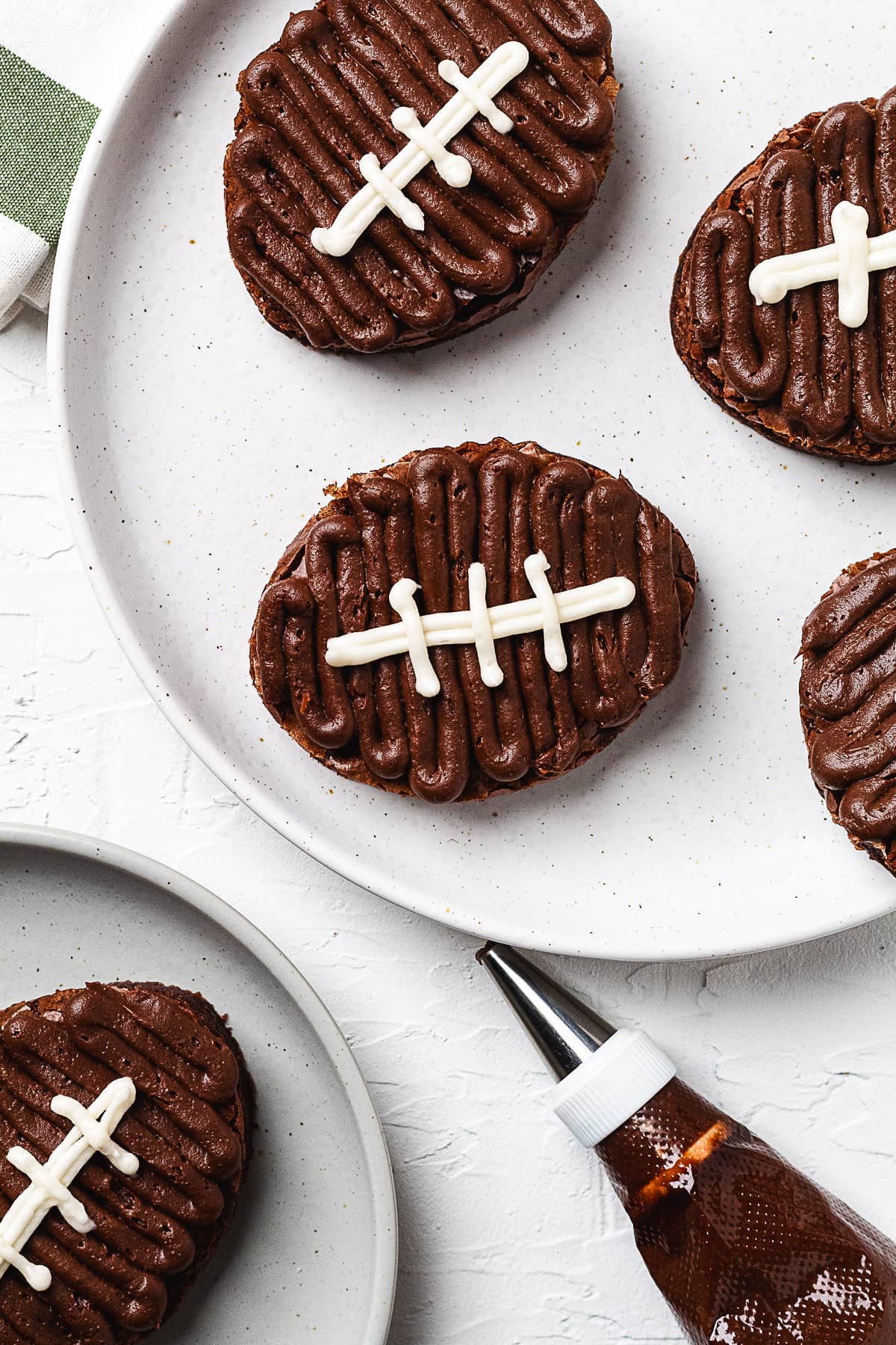 Plate of football brownies decorated with chocolate frosting and white icing details.