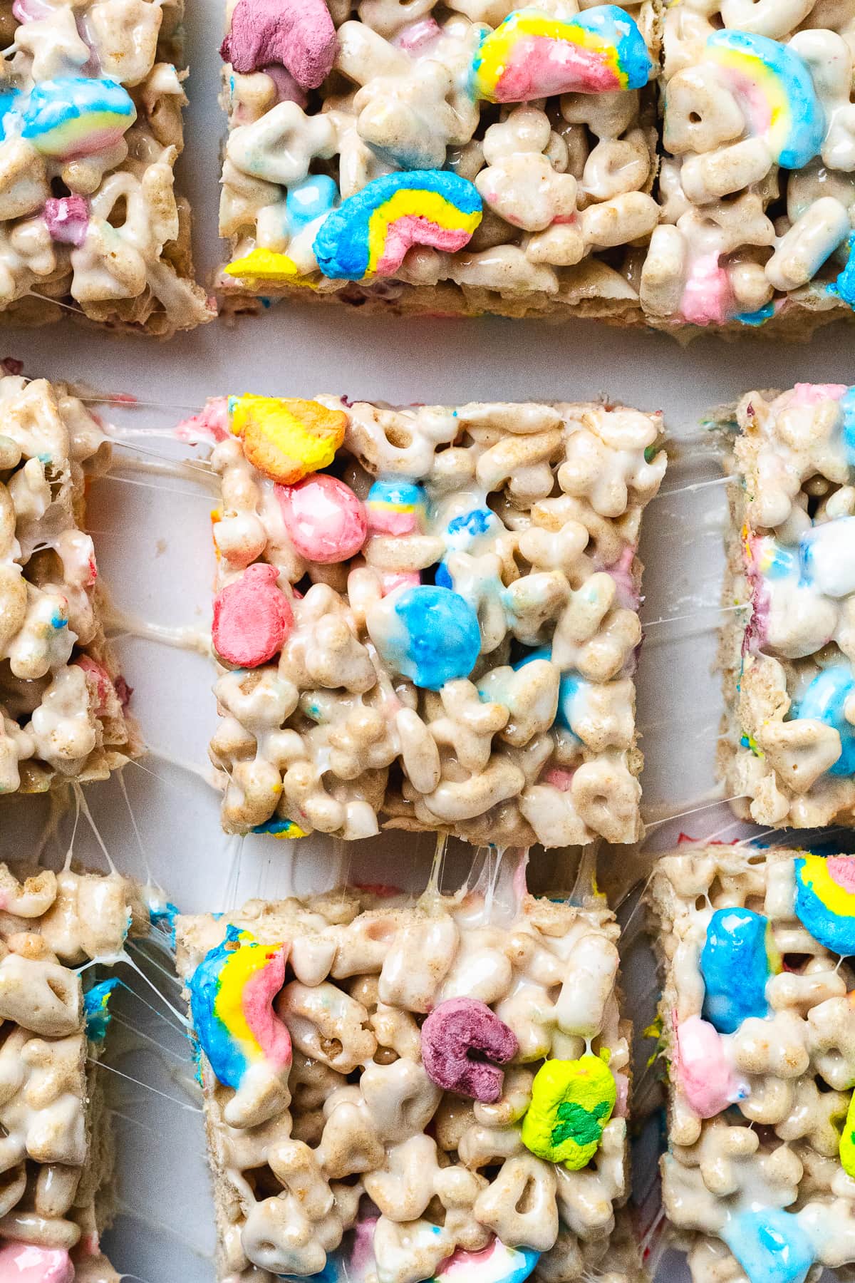 Close-up of cut Lucky Charms treats with colorful marshmallows and gooey texture.