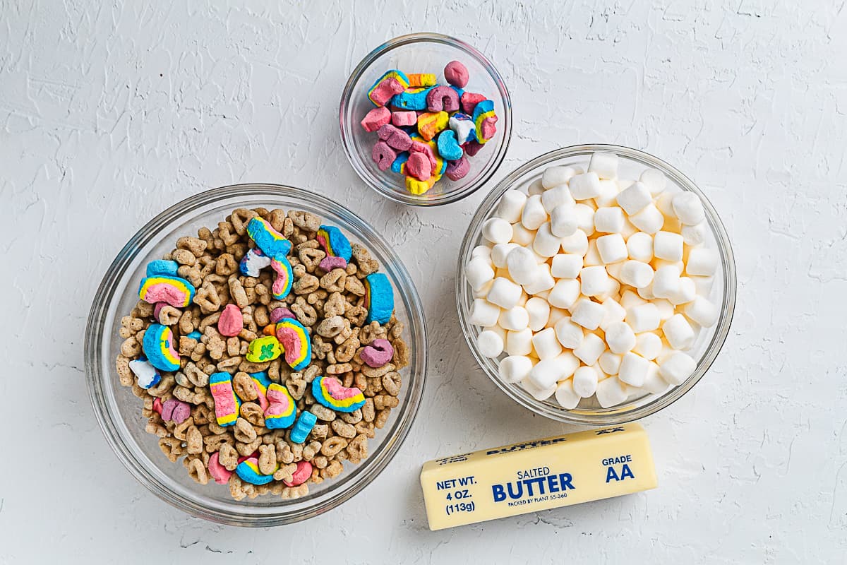 Bowls of Lucky Charms cereal, marshmallows, and butter for making cereal treats.