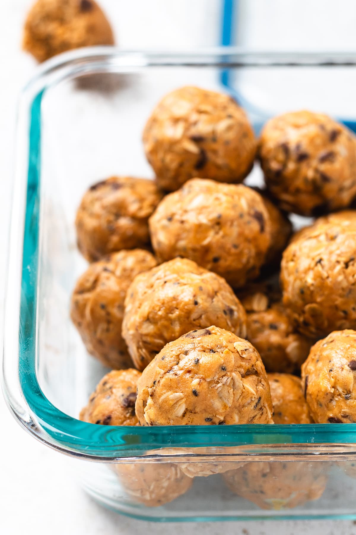 Glass container filled with no bake protein balls ready for storing.