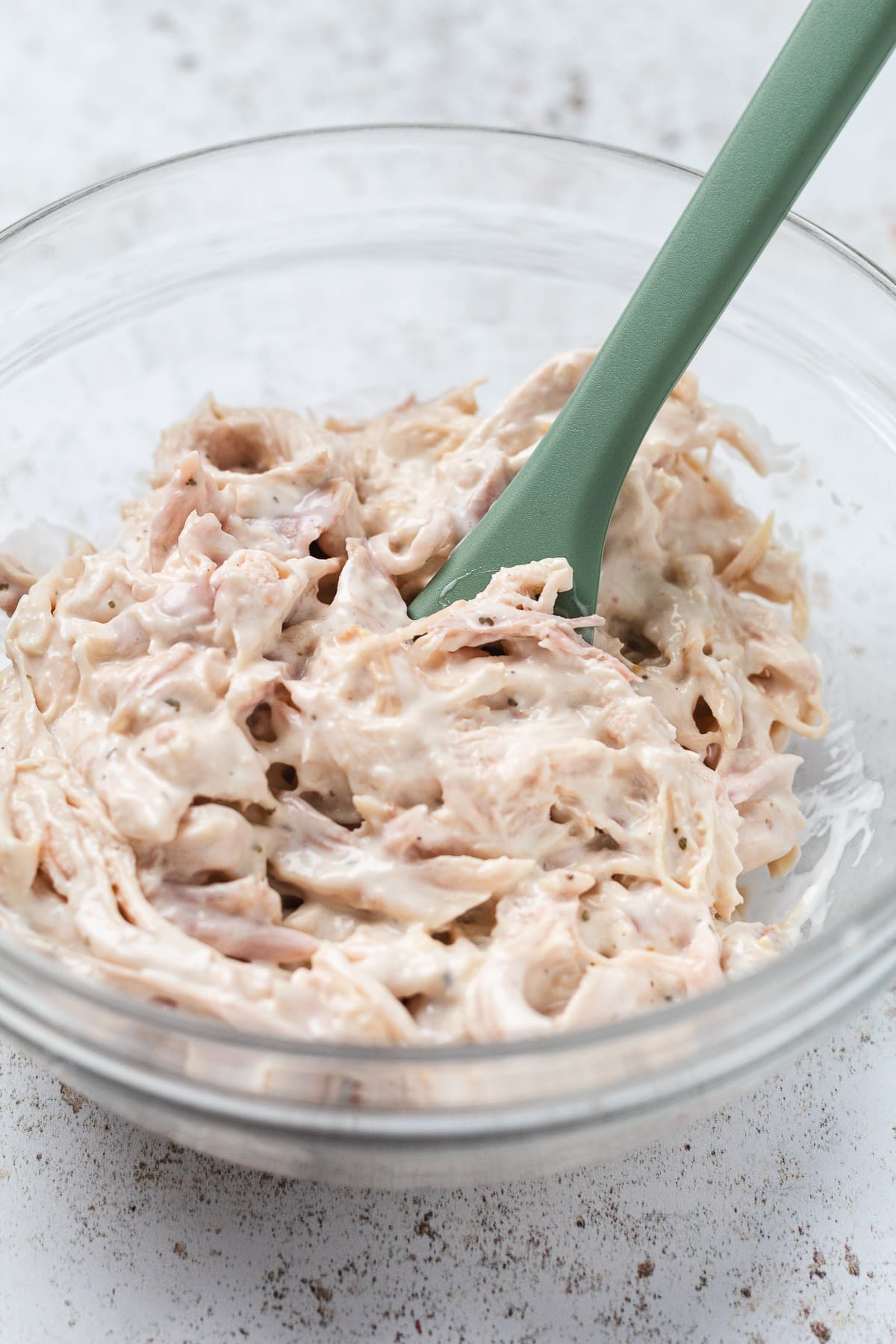 Bowl of shredded chicken mixed with creamy ranch sauce for slider filling.