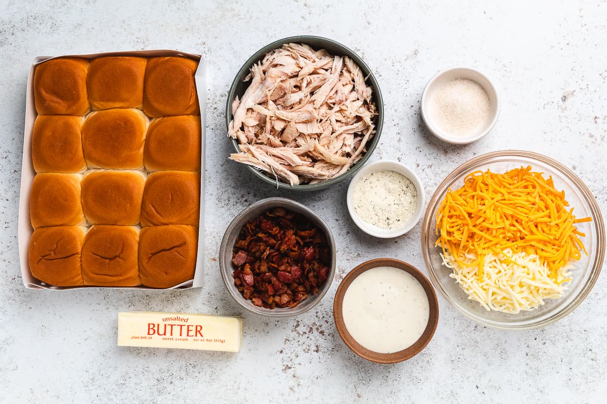 Ingredients for chicken bacon ranch sliders arranged on a table before assembly.