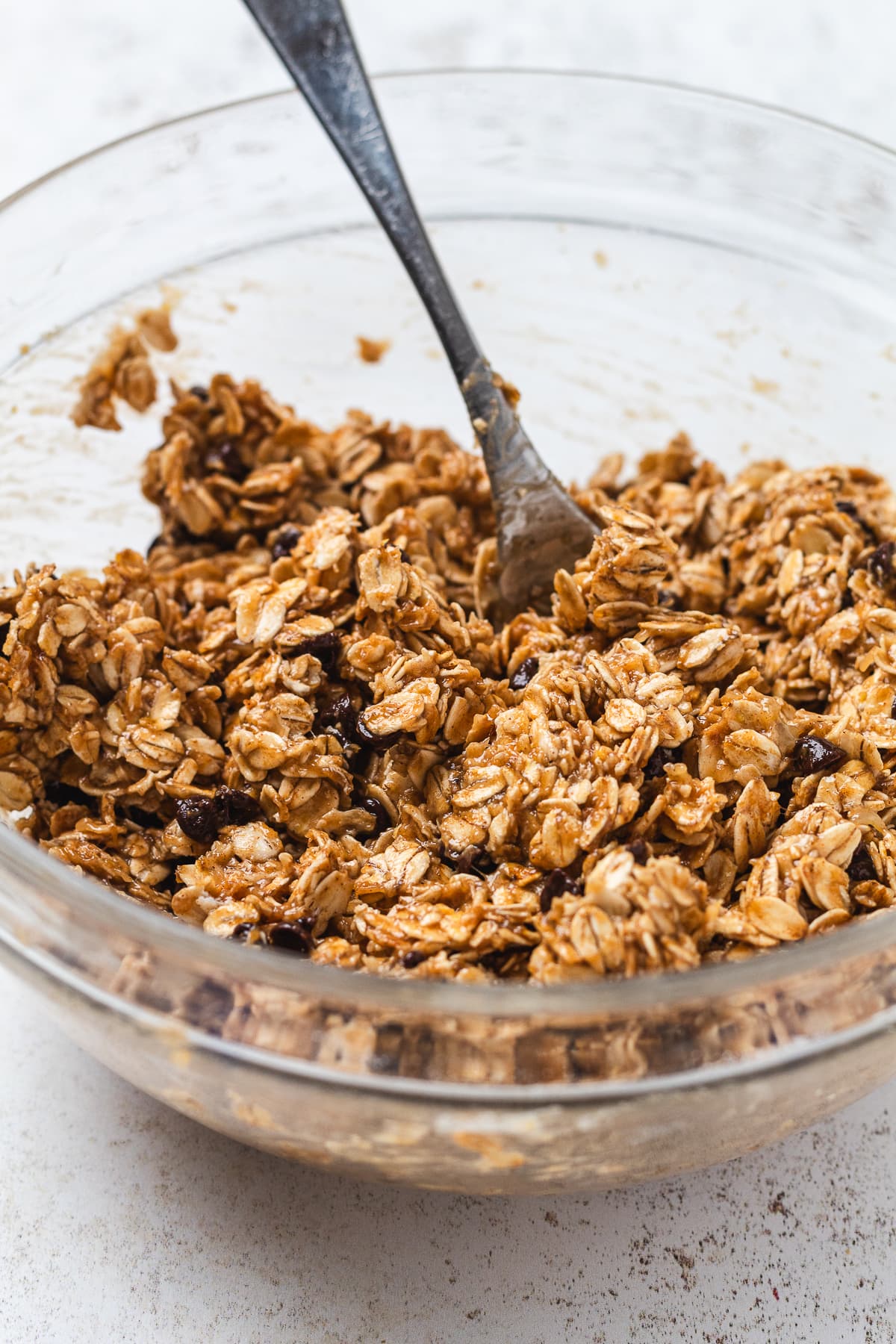 Bowl of banana oat energy bite mixture being stirred with a fork.