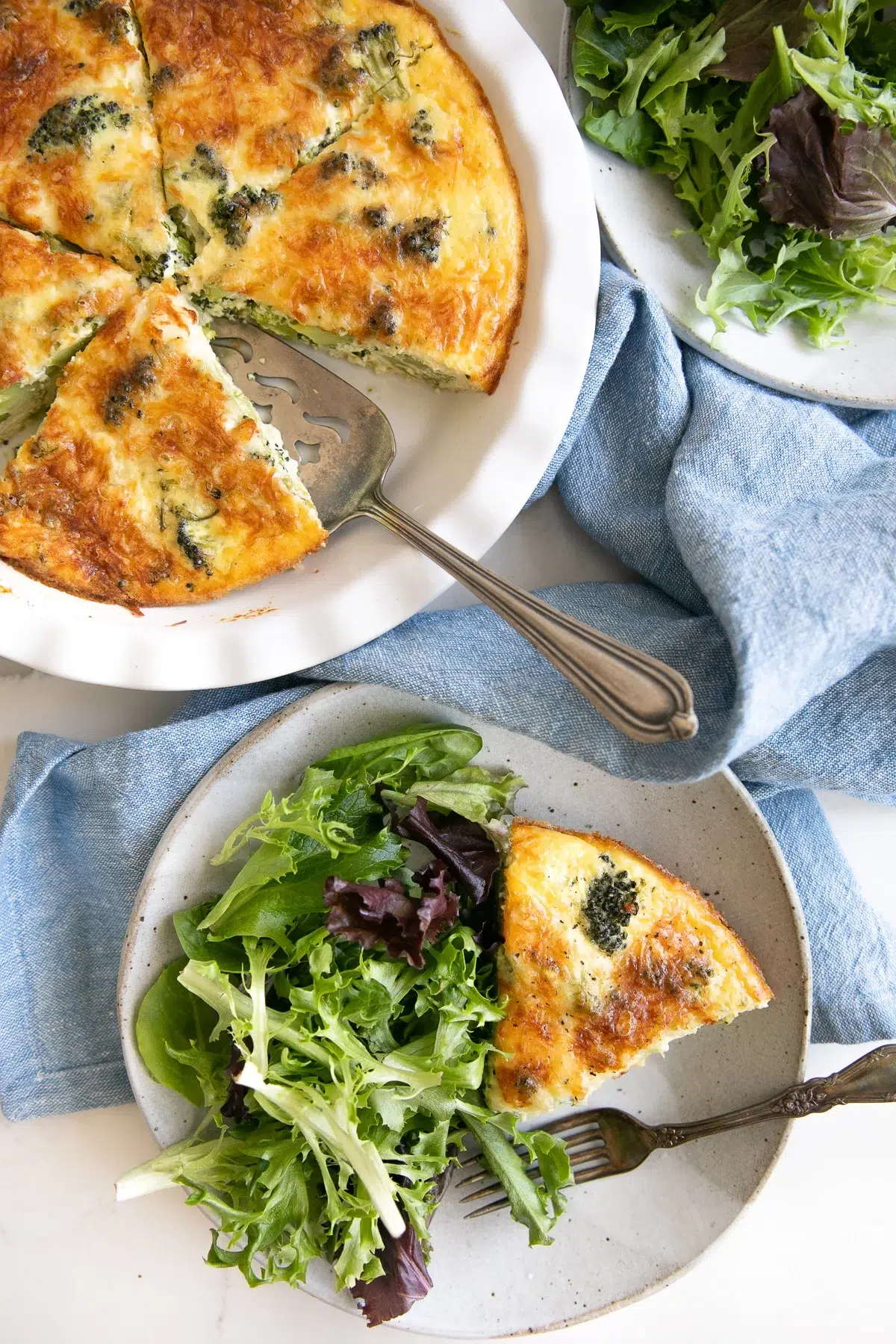 Broccoli crustless quiche served with a side salad on a plate.