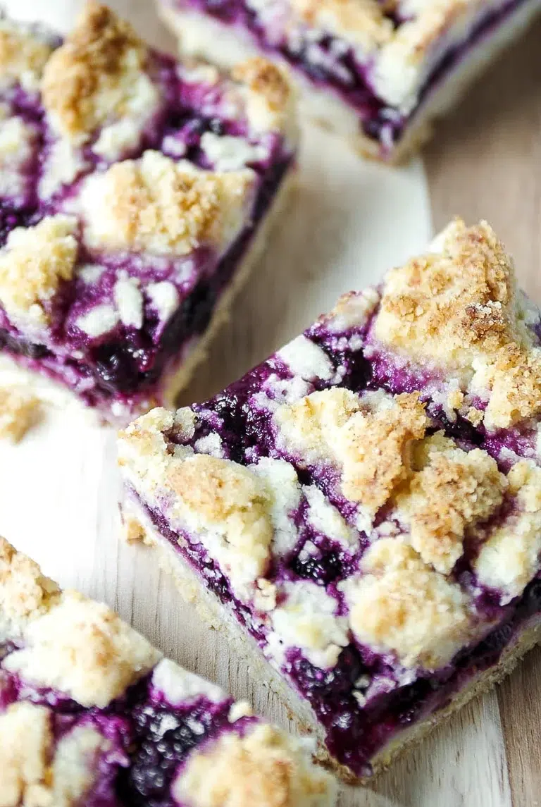Blueberry crumb bars with buttery crumble topping and vibrant purple filling.