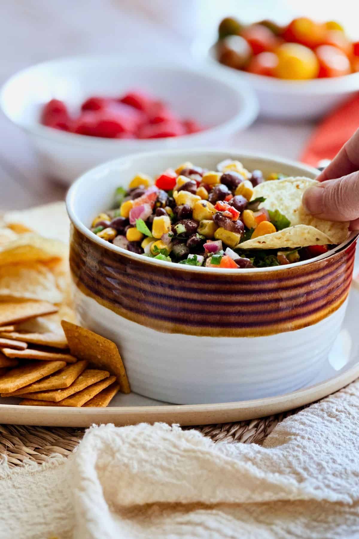 Corn and black bean salsa with tomatoes, onions, and cilantro served with chips.