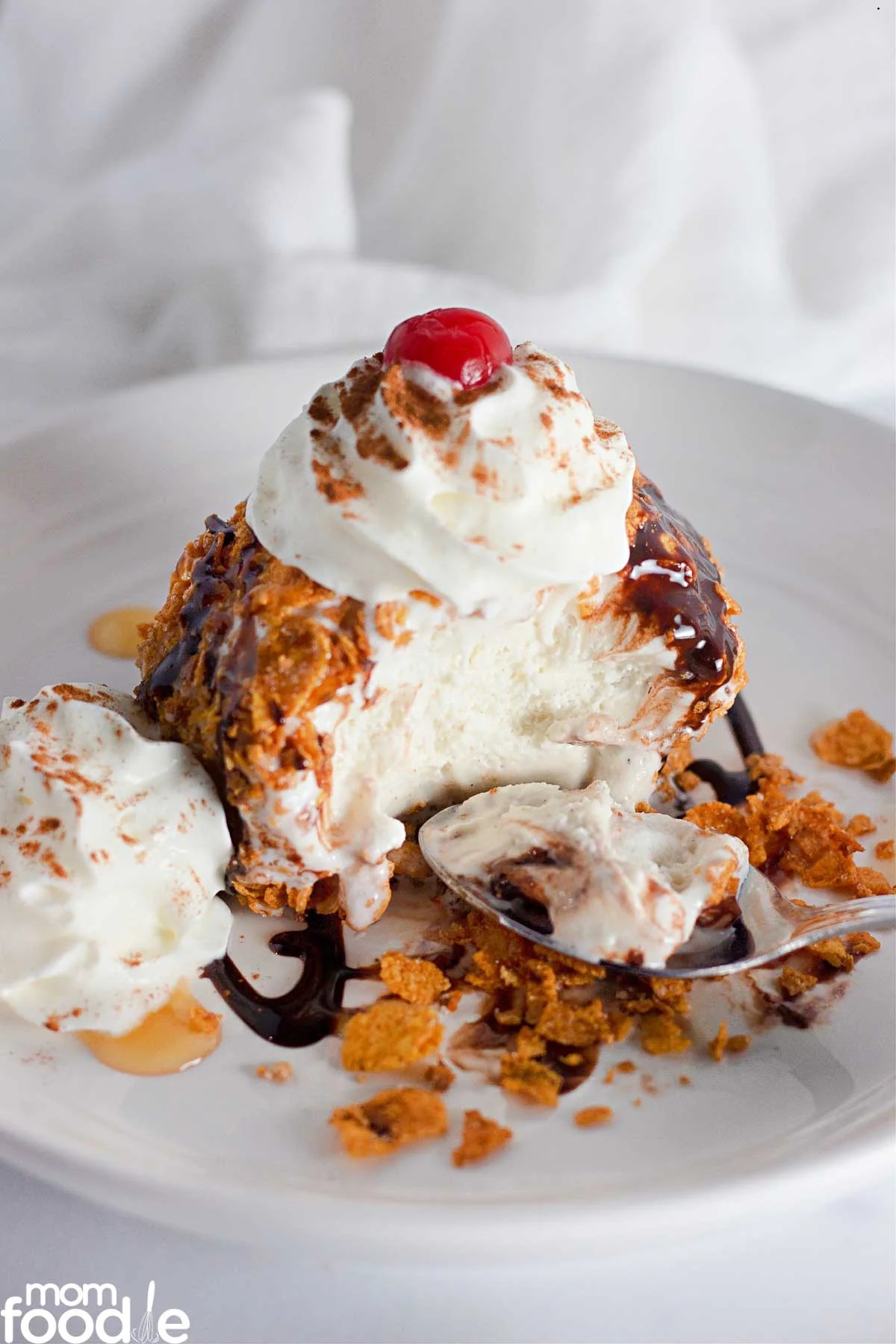 Fried ice cream topped with whipped cream, chocolate, and a cherry.