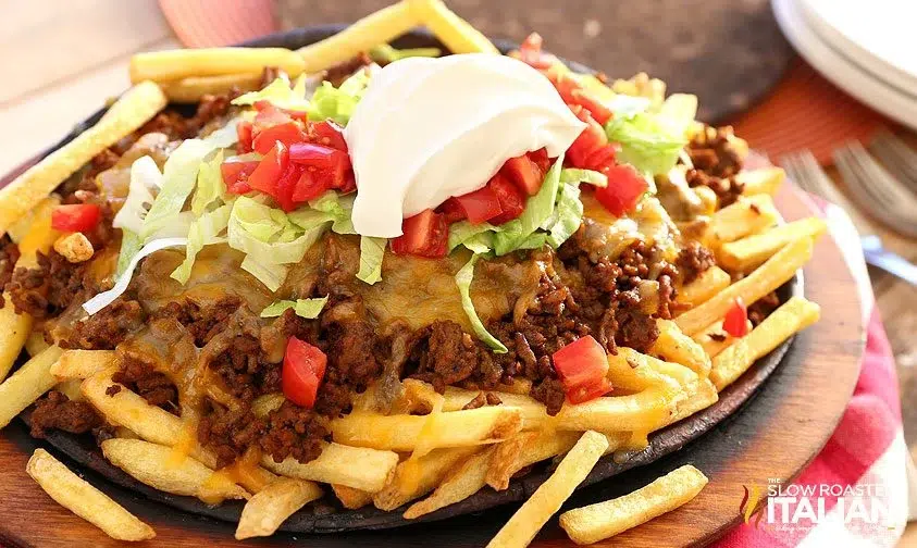 Loaded taco fries topped with ground beef, cheese, lettuce, tomatoes, and sour cream.