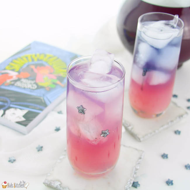 Two layered galaxy lemonade drinks with pink, purple, and blue hues in tall glasses with ice.