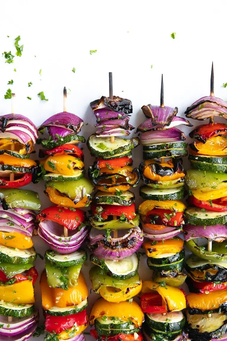 Grilled vegetable skewers with zucchini, peppers, and red onions.