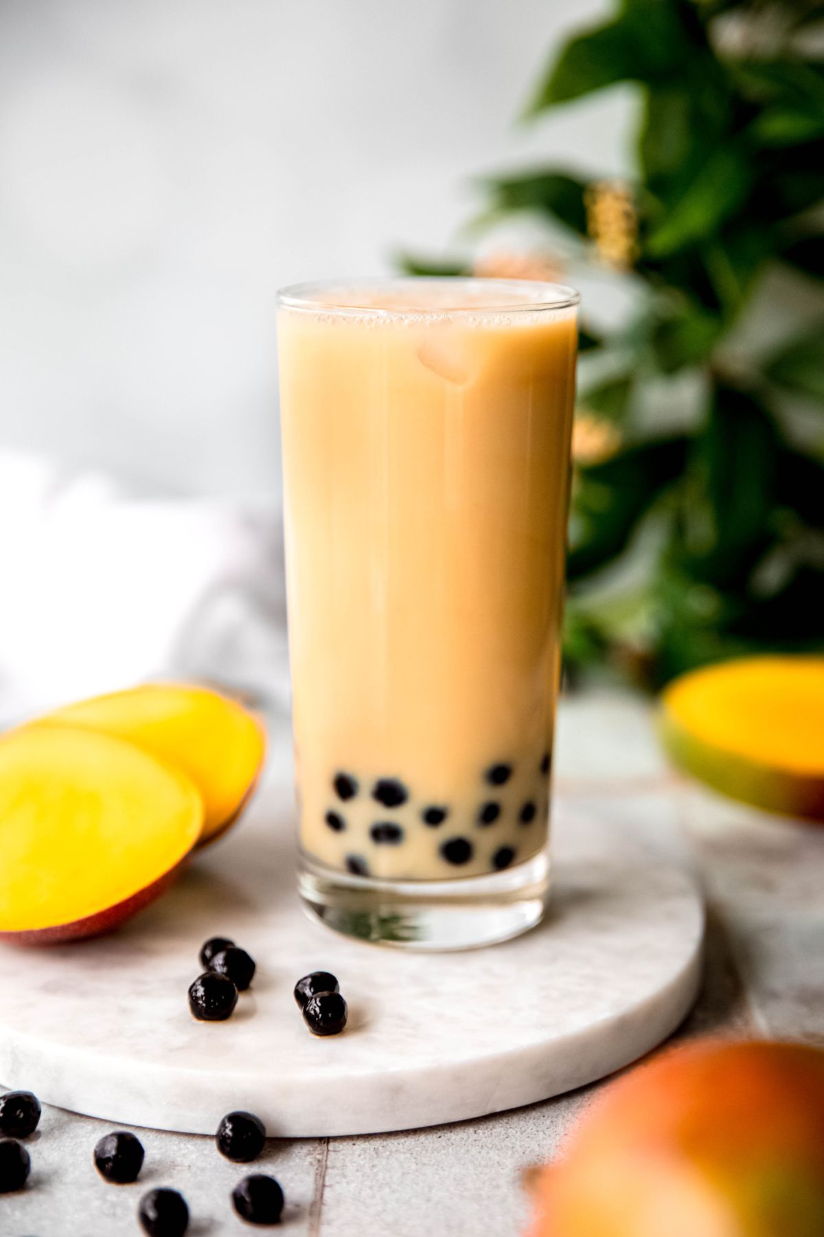 Mango milk tea with tapioca pearls over ice.