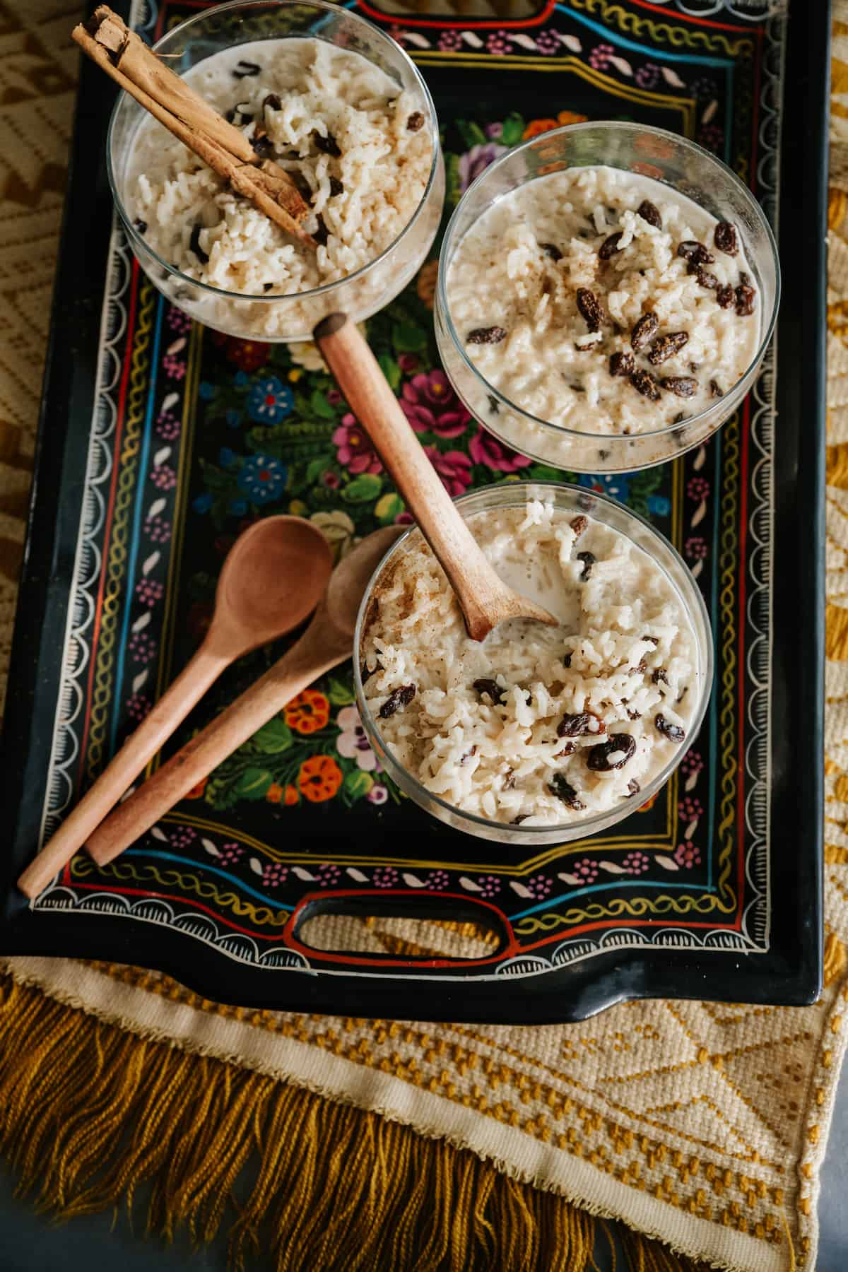 Arroz con leche with raisins and cinnamon in glass bowls.