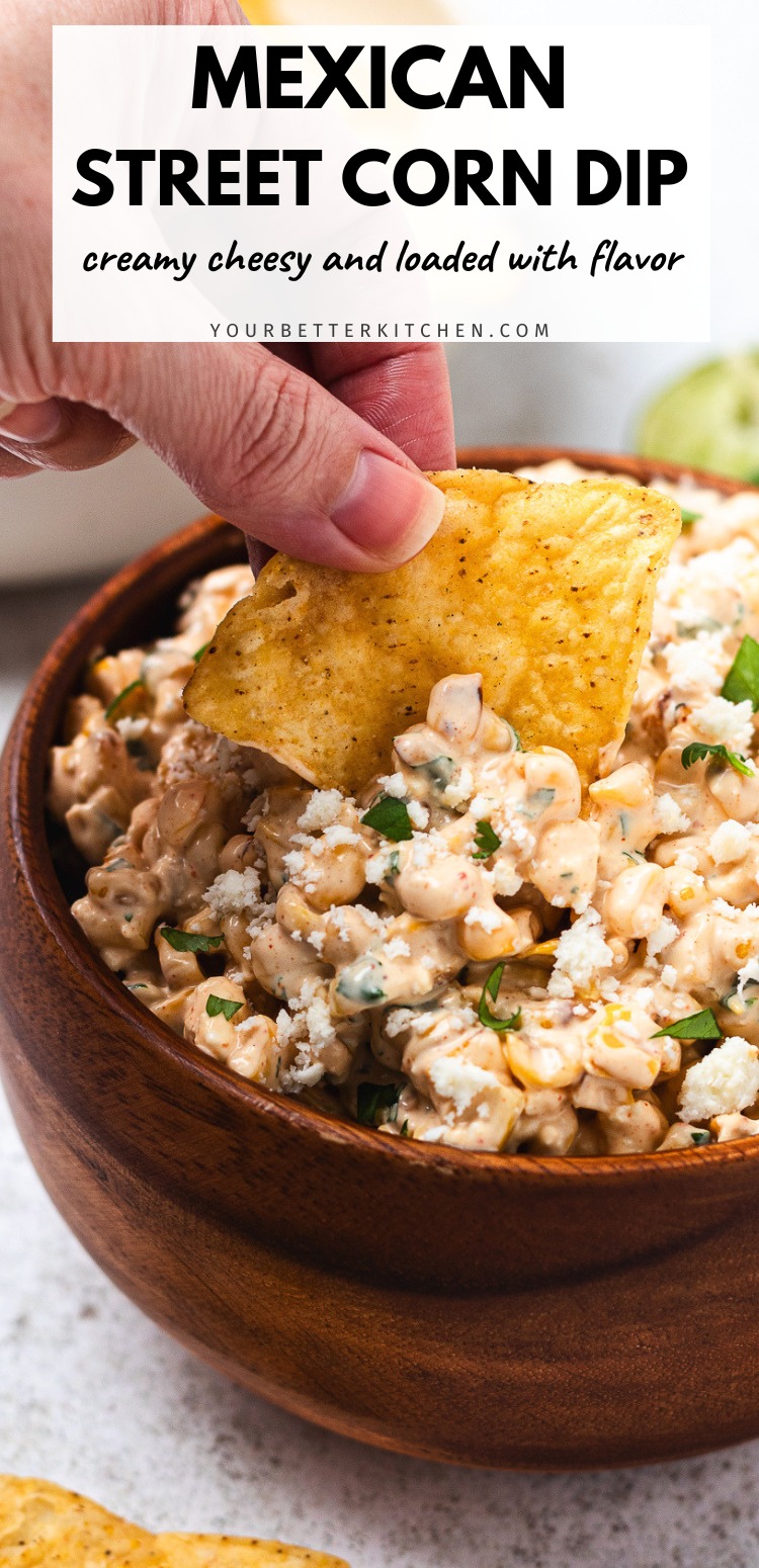 Bowl of Mexican street corn dip with a chip being dipped with text that says Mexican Street Corn Dip, creamy, cheesy, and loaded with flavor.