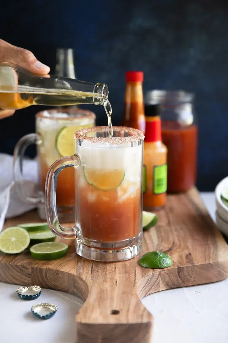 Michelada beer cocktail with lime, hot sauce, and salted rim.