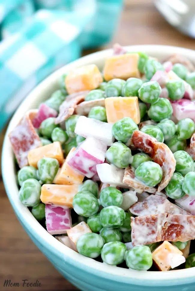 Classic pea salad with cheese cubes, bacon, and red onions.