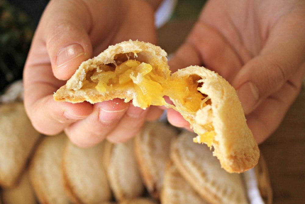 Pineapple empanada broken open showing warm fruit filling.