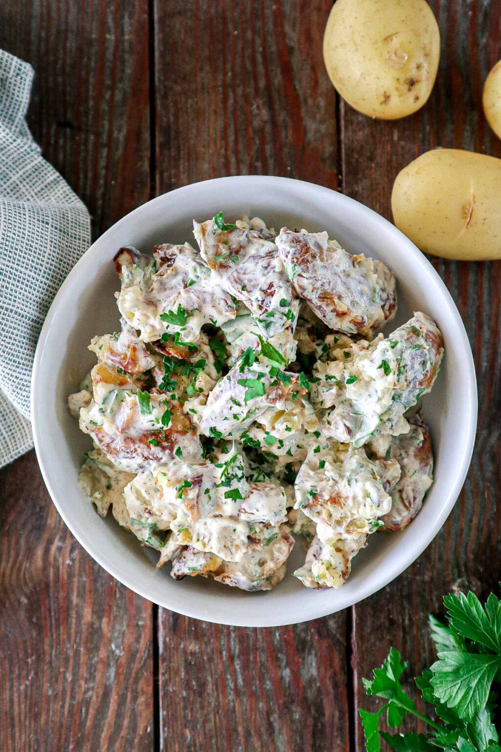 Creamy smashed potato salad with herbs and dressing.