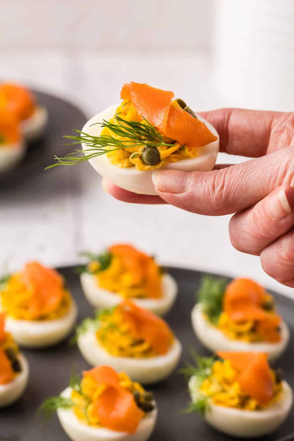 Smoked salmon deviled eggs topped with dill and capers.