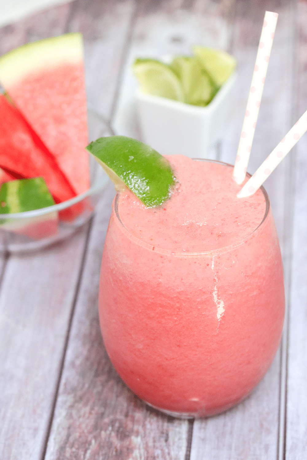 Frozen watermelon slushie with lime garnish.