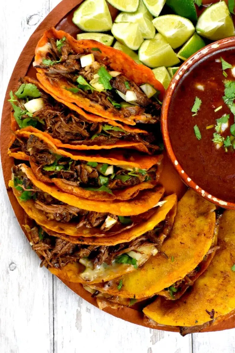 Birria tacos stuffed with shredded beef, cilantro, and onions served with dipping broth.