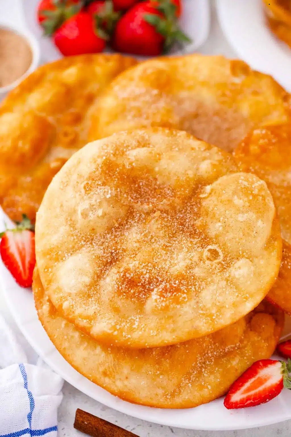 Crispy bunuelos dusted with sugar served with fresh strawberries.