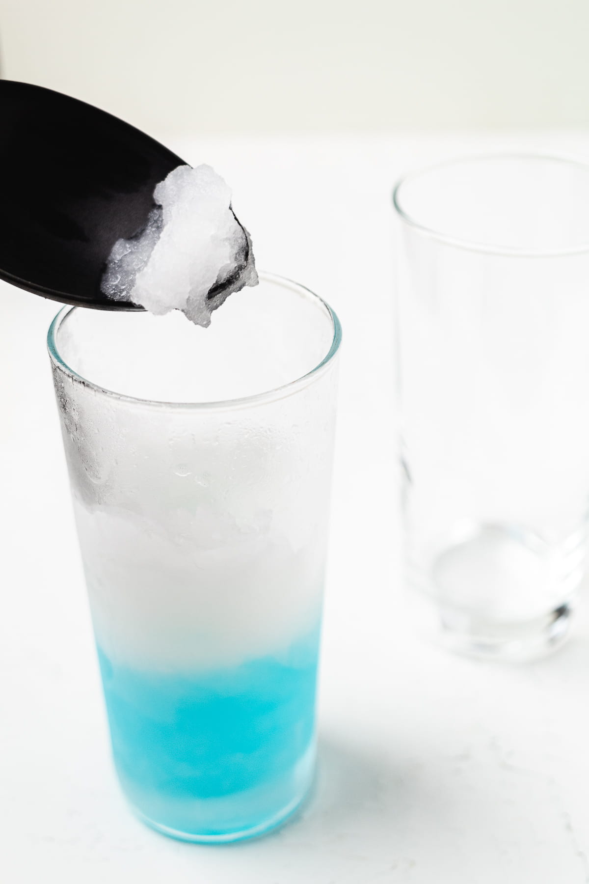 Adding a white margarita layer on top of the blue margarita layer.