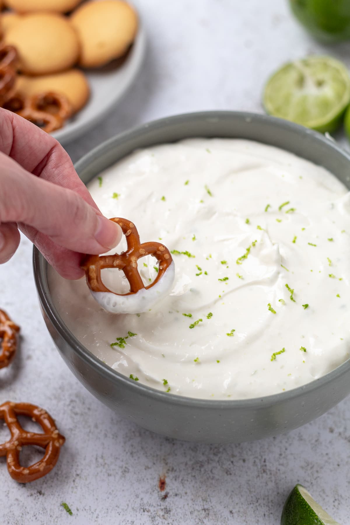 Creamy margarita dip with lime zest and a pretzel for dipping.