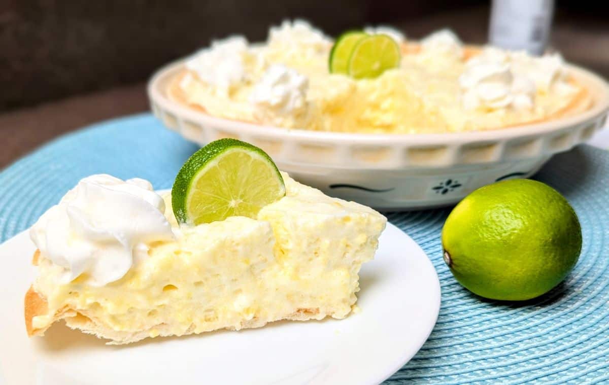Slice of margarita pie topped with whipped cream and lime garnish.