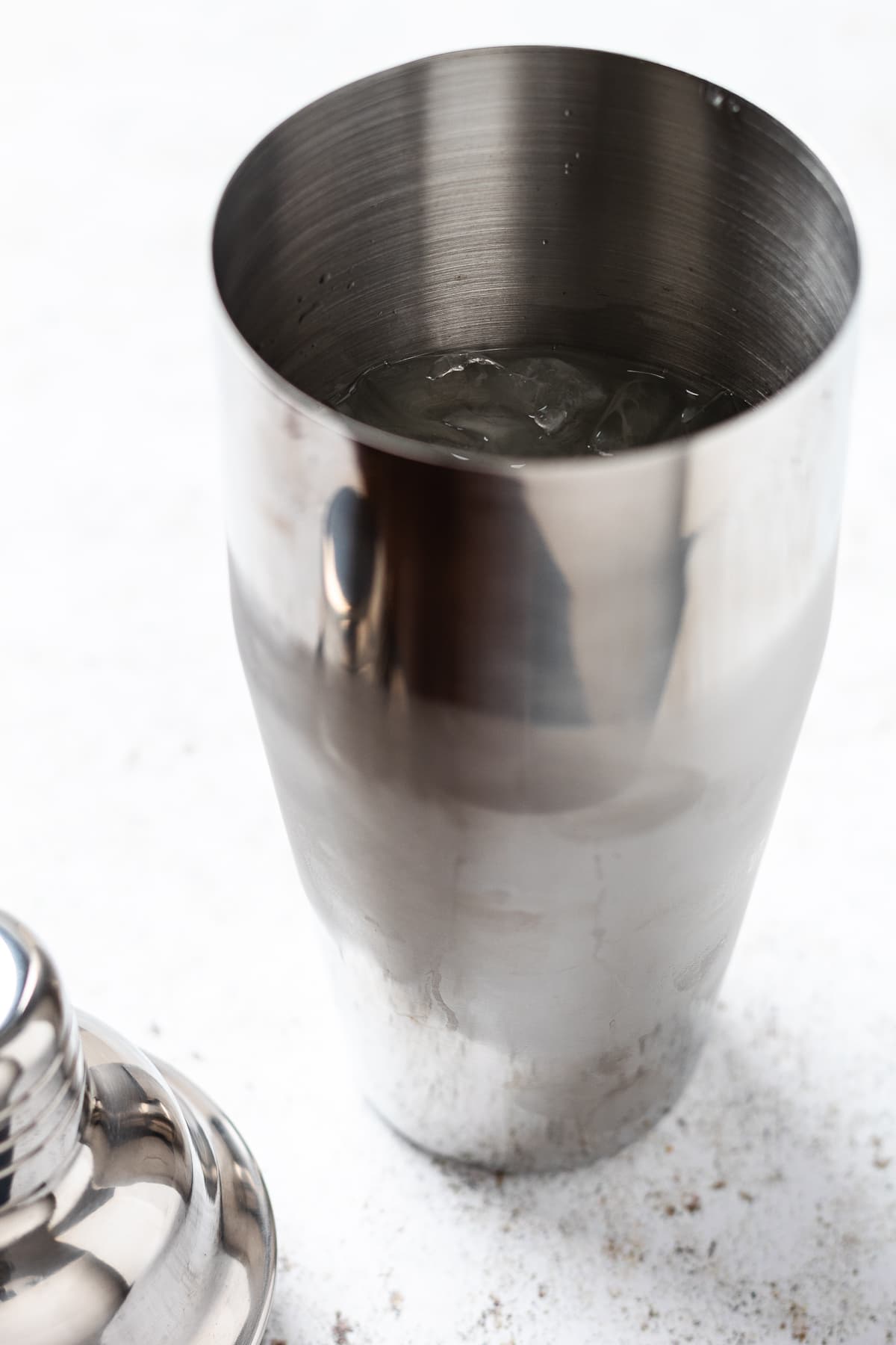 Image of a cocktail shaker with ice, showing the margarita being prepared before shaking.