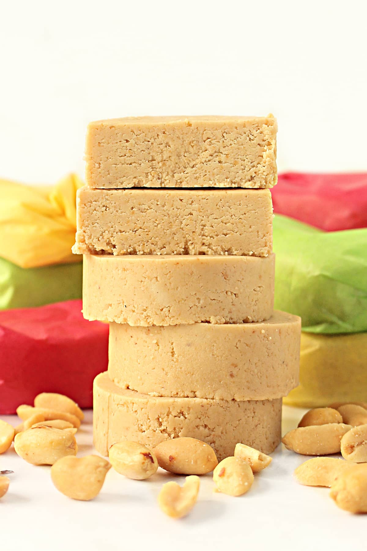 Stacked mazapan peanut candy rounds with whole peanuts around.