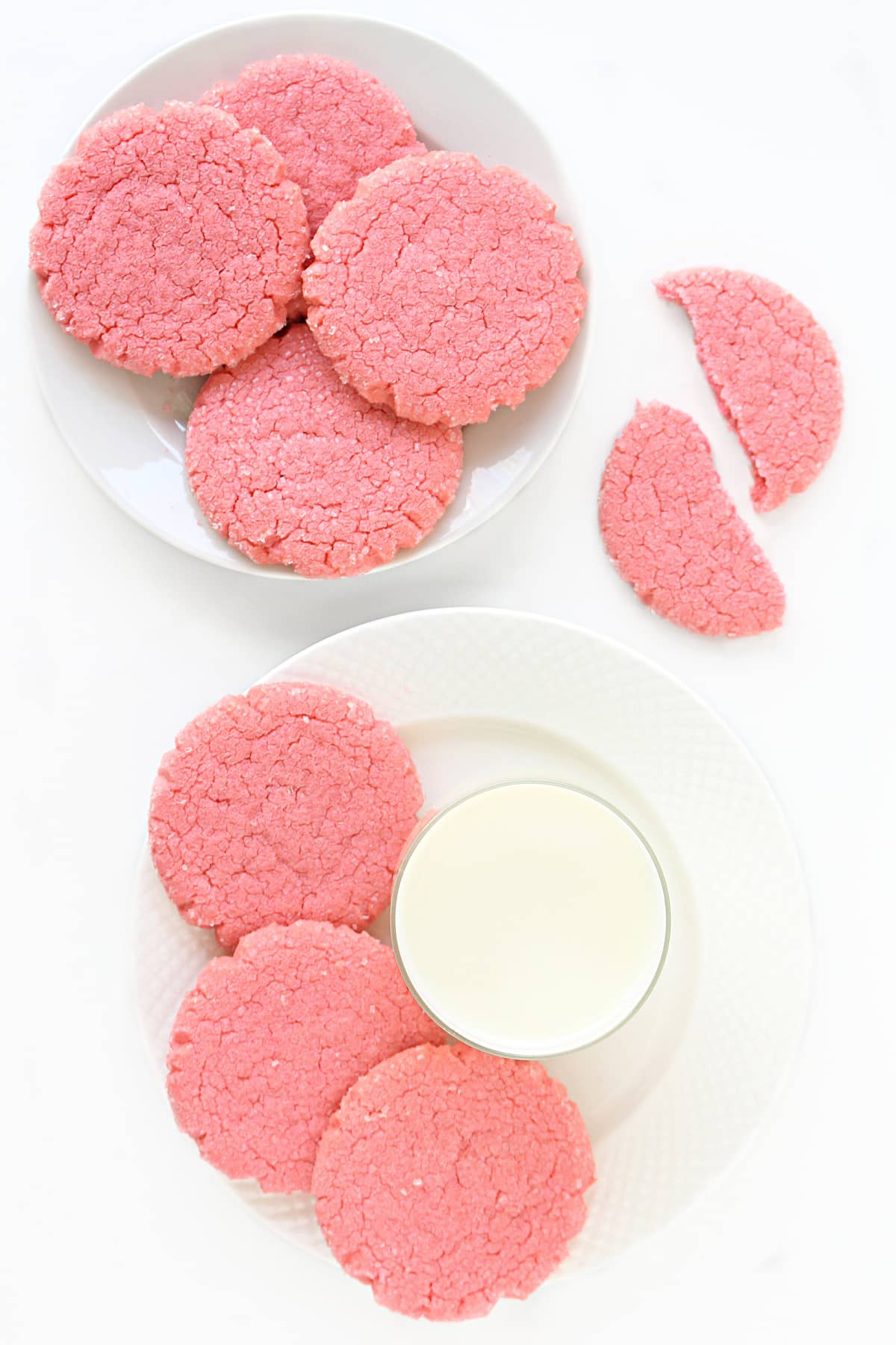 Pink Mexican sugar cookies served with a glass of milk.
