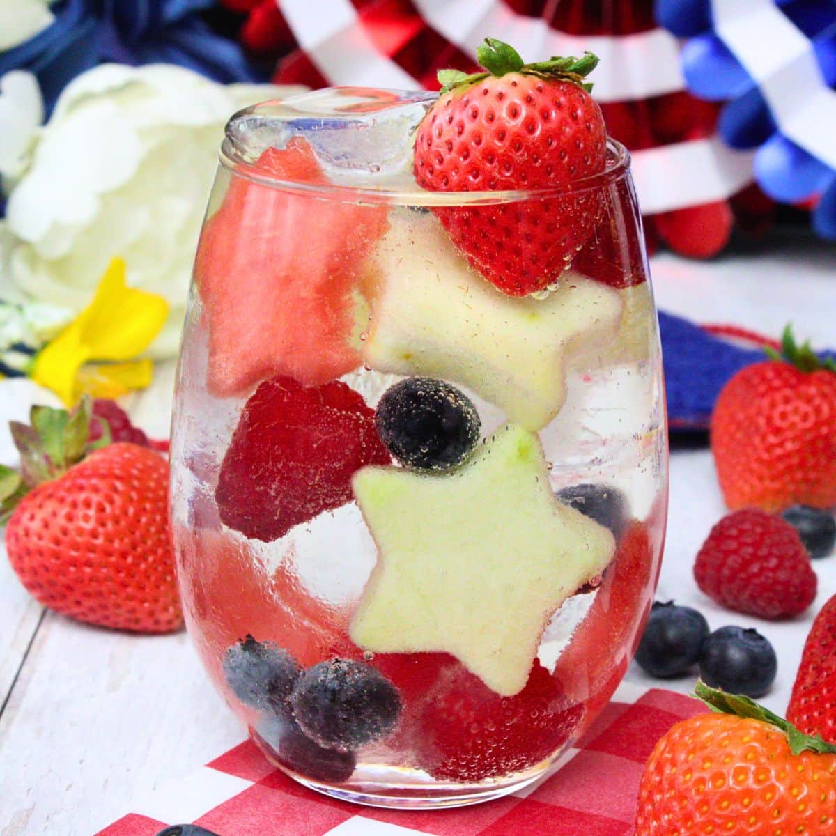 Red, white, and blue sangria with strawberries, blueberries, and star-shaped fruit slices.